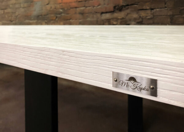 Stół Szum - Design Zbliżenie na połączenie białego blatu z czarną metalową nogą w stole Szum