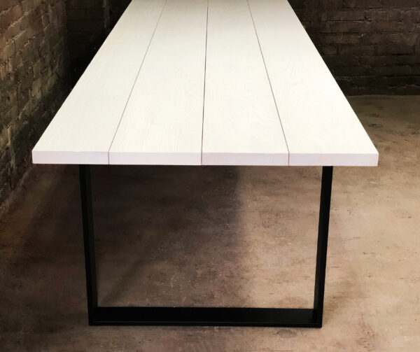 Stół Szum - Stabilna Konstrukcja Prostokątny stół z białym blatem na stabilnych płozach w ciemnym wnętrzu